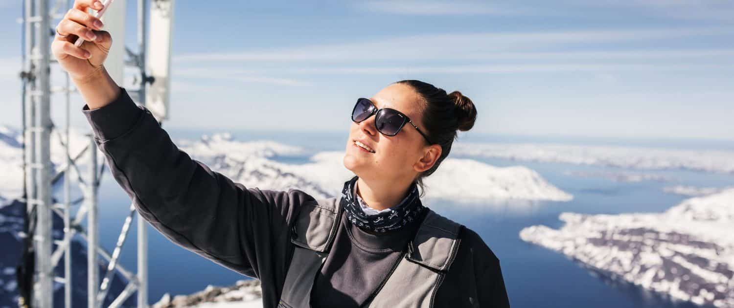 Tele-Post's employee takes a selfie picture at the top of Qingaaq mountain in Nuuk fjord. Photo by Filip Gielda