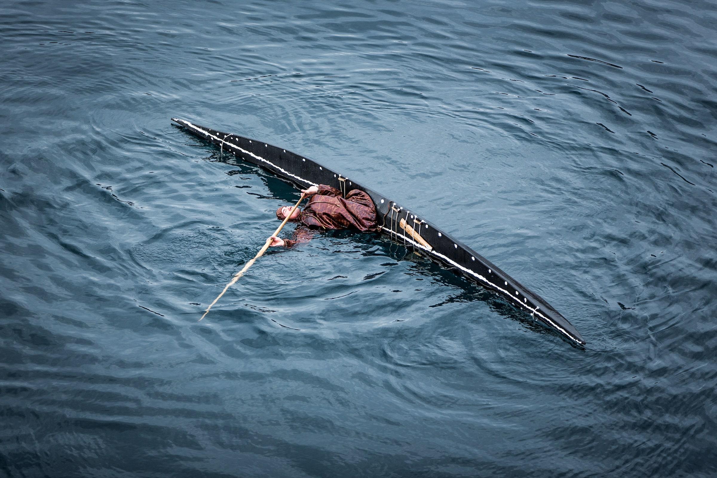 A Greenlandic kayaker from Sisimiut performaing a roll in a traditional kayak. Photo by Mads Pihl