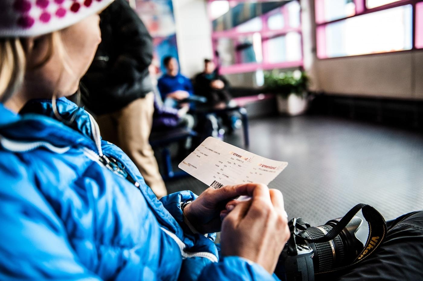 A traveler waiting to board a plane from Ilulissat in Greenland. Photo by Camilla Hylleberg - Visit Greenland