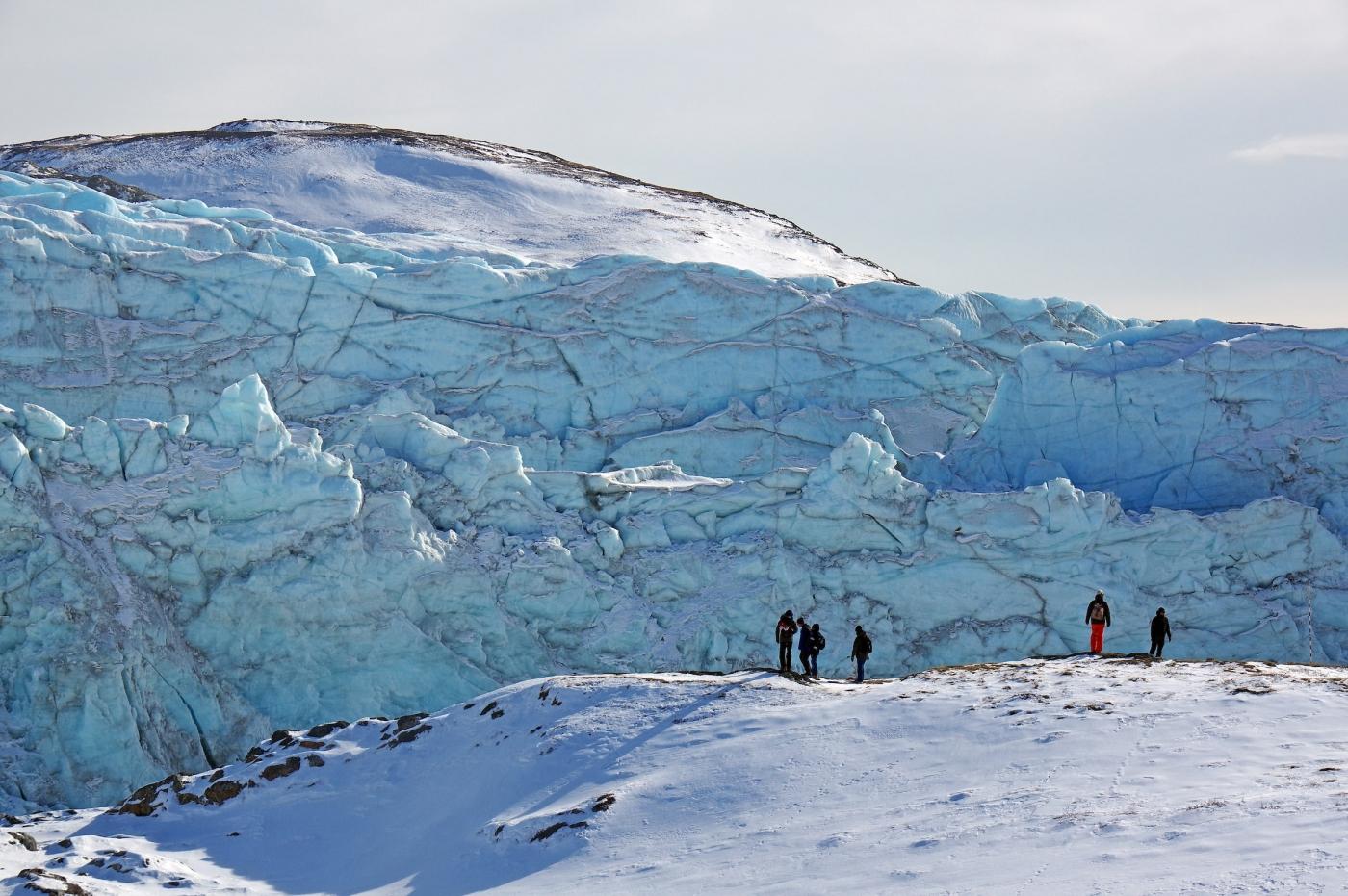 Tourists admiring the front face of Russell Glacier, close to Kangerlussuaq, on a clear winter's day. Photo by Reinhard Pantke - Visit Greenland