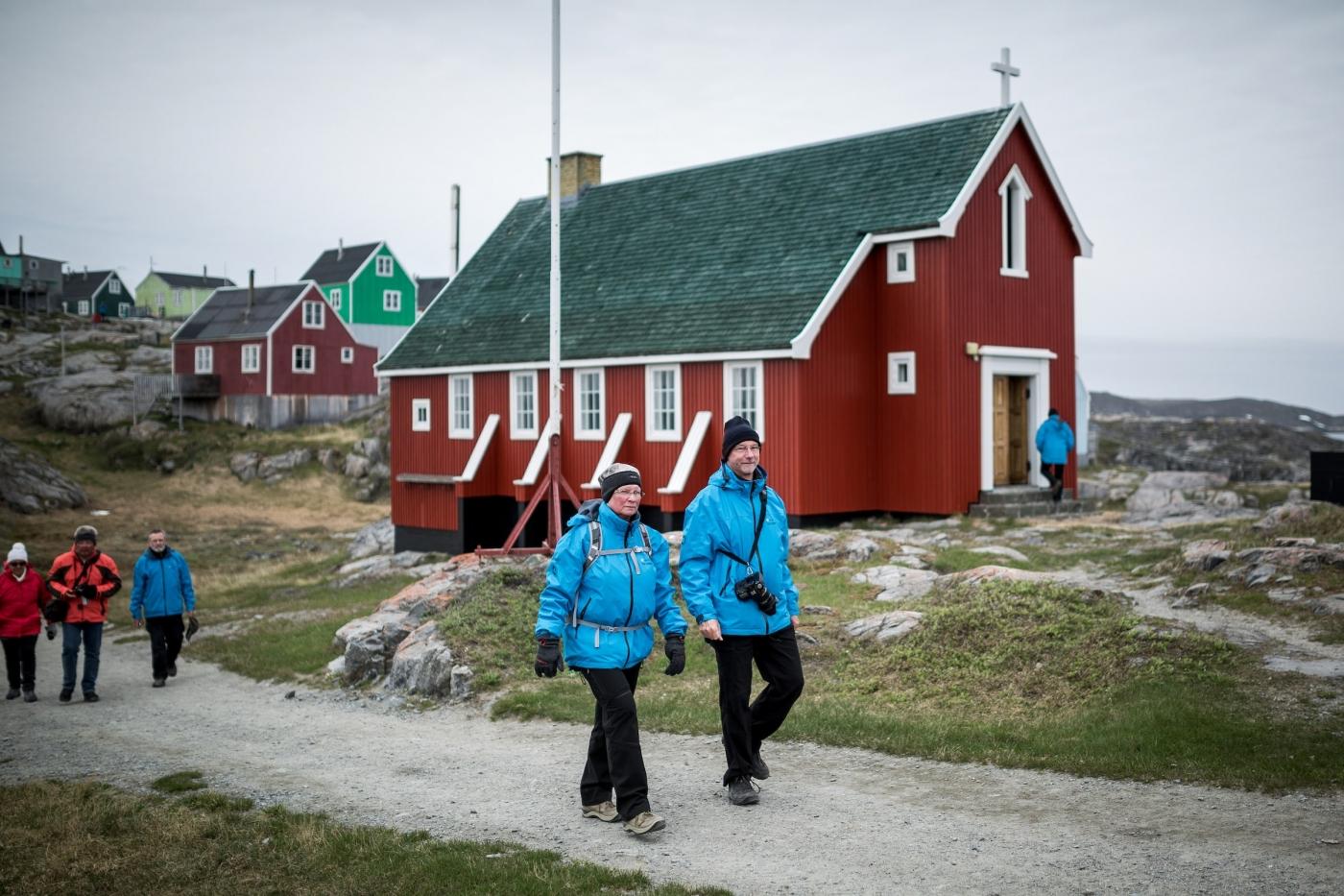 MS Fram cruise guests walking by the church in Itilleq in Greenland. Photo by Mads Pihl - Visit Greenland