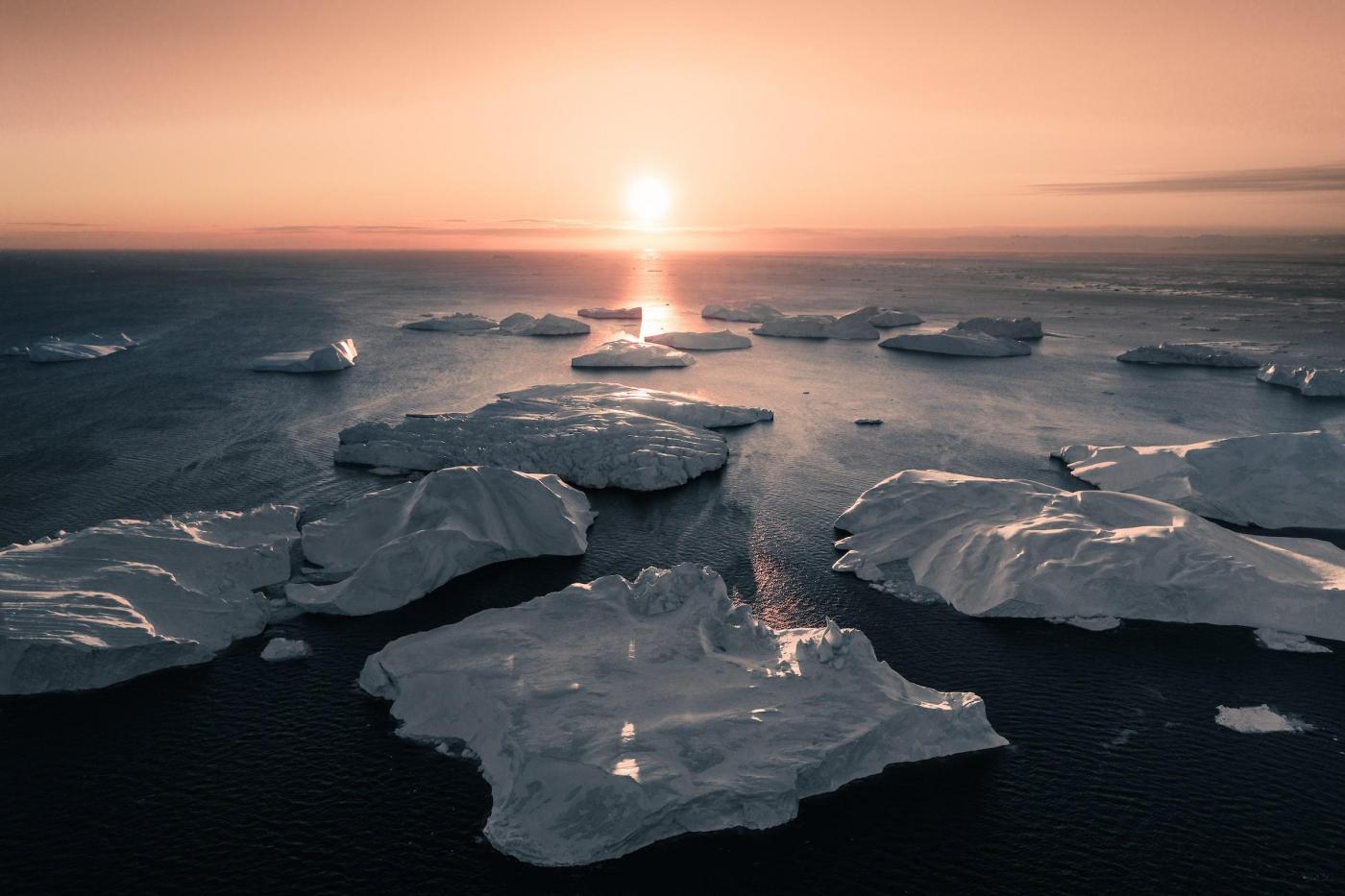 Sun aligned with icebergs in Ilulissat. Photo - Ben S. Rehn, Visit Greenland