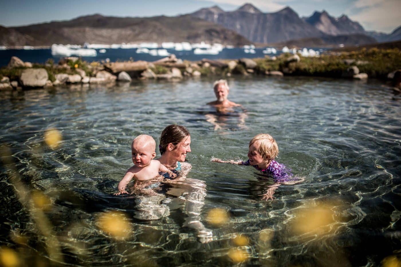 A family swimming in the Uunartoq hot springs in South Greenland, by Mads Pihl - Visit Greenland