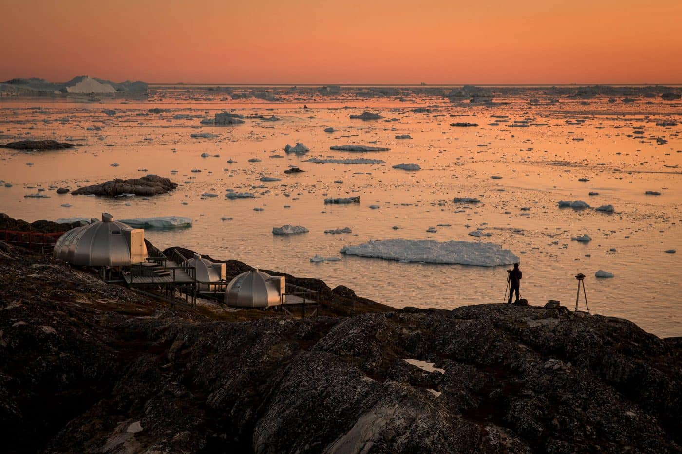 A photographer in the sunset near Hotel Arctic in Ilulissat in Greenland. By Mads Pihl