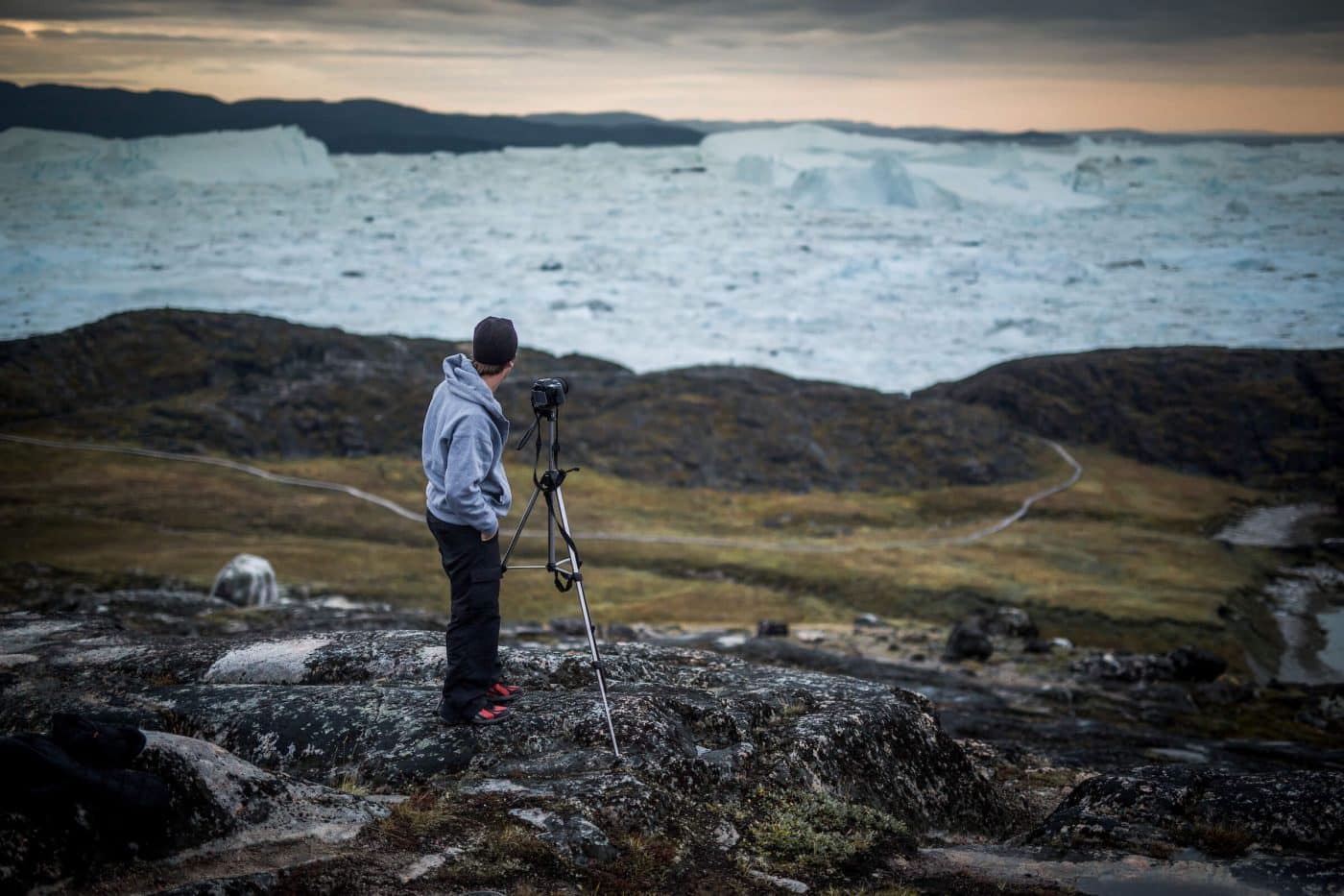A photographer near the Ilulissat ice fjord in Greenland. By Mads Pihl