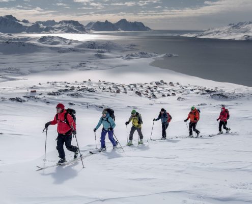 A group of skiers climbing a mountain near Kulusuk on a ski touring trip in East Greenland. Photo by Mads Pihl, Visit Greenland