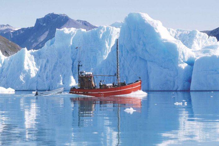 Saling vessel between icebergs in Greenland. Photo by Blue Ice Explorer