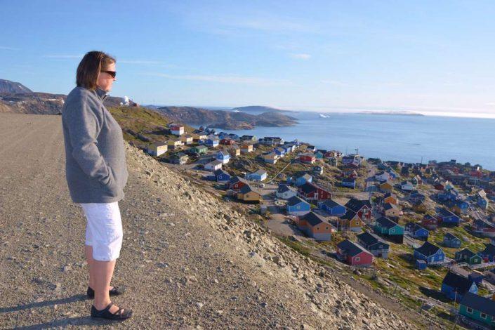 Woman looking over the sea and Upernavik. Photo by John Kislov