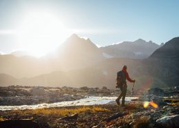 Hiker looking at the mountains during sunset near river, Near Camp In Tasiilaq Fjord. By Chris Brinlee Jr