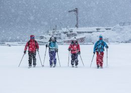 Ski touring skiers in heavy snowfall in Kuummiut in East Greenland. Photo by Mads Pihl