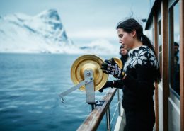 The deckhand Line fishing on a tour with Arctic Boat Charter in the Nuuk fjord in Greenland. Photo by Rebecca Gustafsson