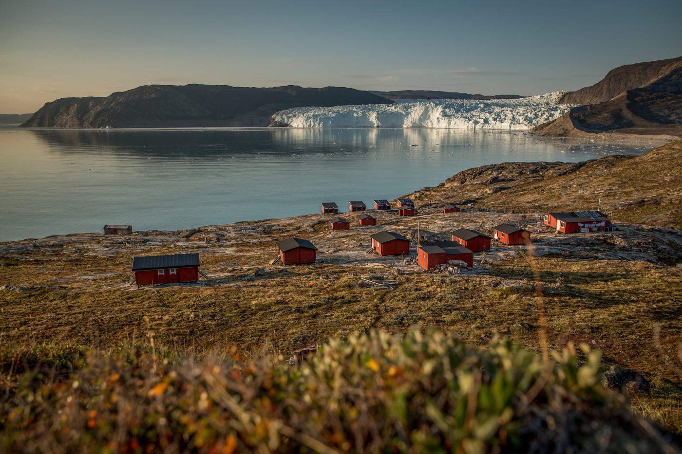 An overview of the Eqi Glacier Lodge camp with the glacier in the background in North Greenland. By Mads Pihl