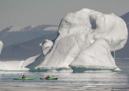Kayakers near an iceberg in Illorsuit in North Greenland. Photo by Mads Pihl.