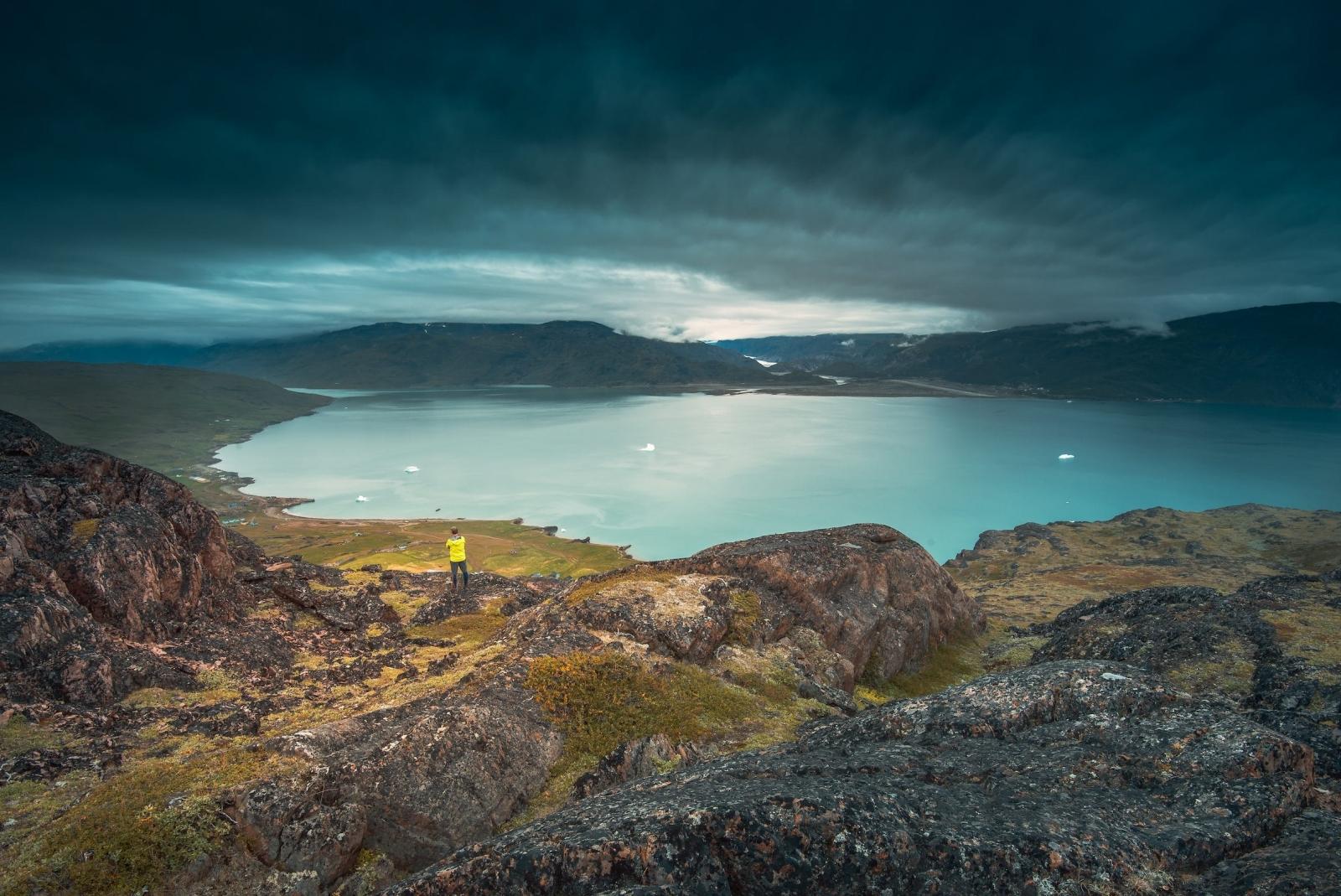 A lone traveller stands in Qassiarsuk and looks over Tunulliarfik Fjord toward Narsarsuaq. Photo by Stacy William Head