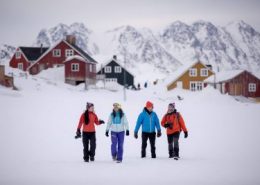 A group of travelers sightseeing by foot in Kulusuk, East Greenland. Photo by Mads Pihl