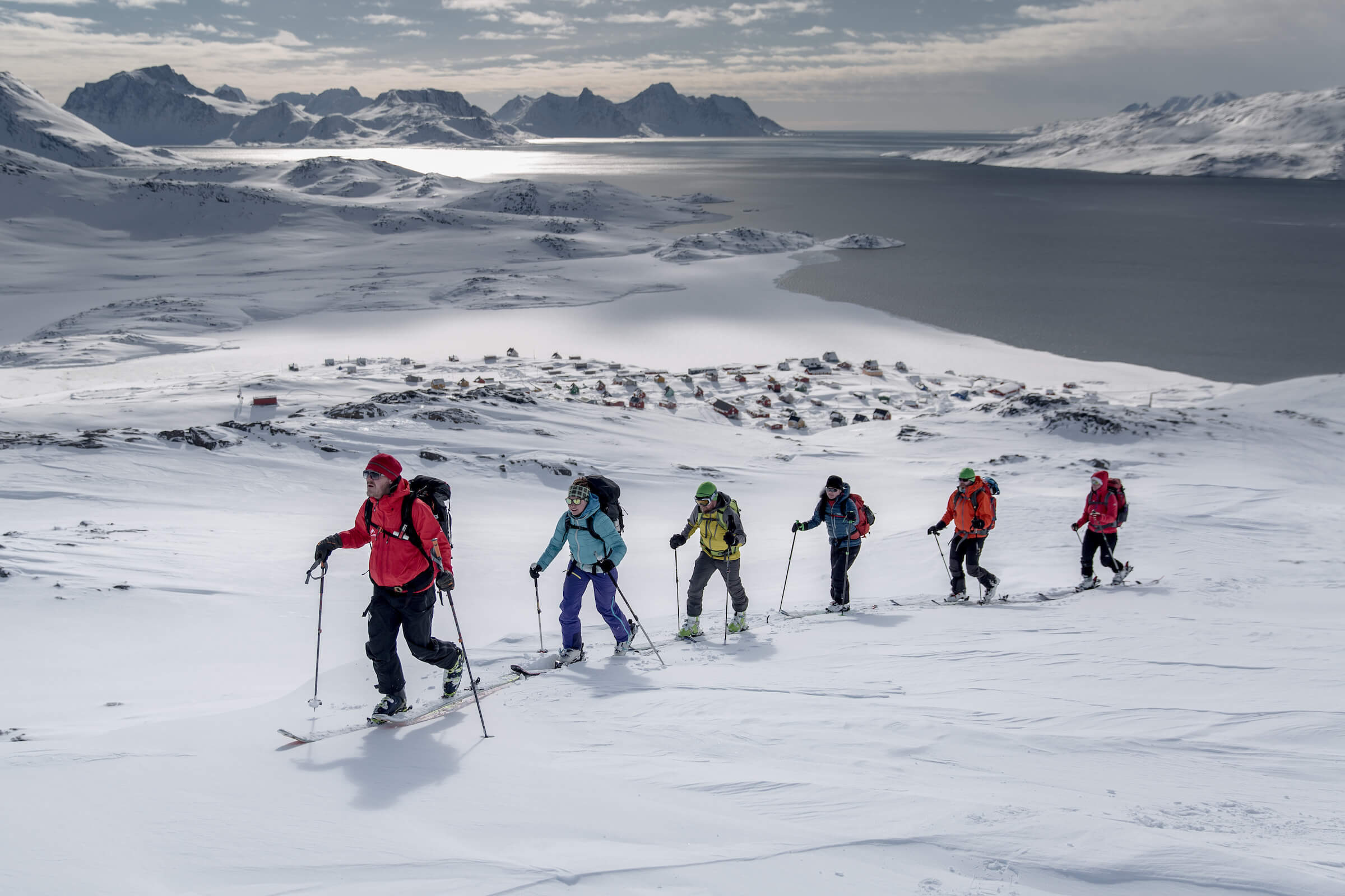 A group of skiers climbing a mountain near Kulusuk on a ski touring trip in East Greenland. Photo by Mads Pihl - Visit Greenland