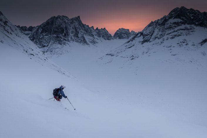 A skier descending from Tasiilaq Mountain Hut in the sunset in East Greenland. By Mads Pihl