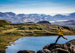 Enthusiastic hiker having fun near the Greenland Ice Sheet along the Arctic Circle. By Raven Eye Photography
