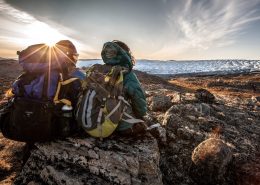 Two hikers enjoying the sunset over the edge of the Greenland Ice Sheet near Kangerlussuaq. By Mads Pihl