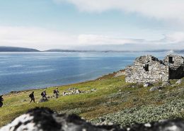 Hikers approaching Hvalsey church ruin one of several norse historical sites in south greenland. By David Trood