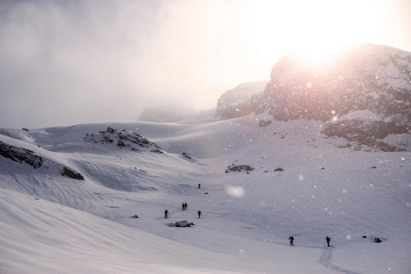 Snowfall with skiers ski touring near Kangaamiut. By Jesper Regin
