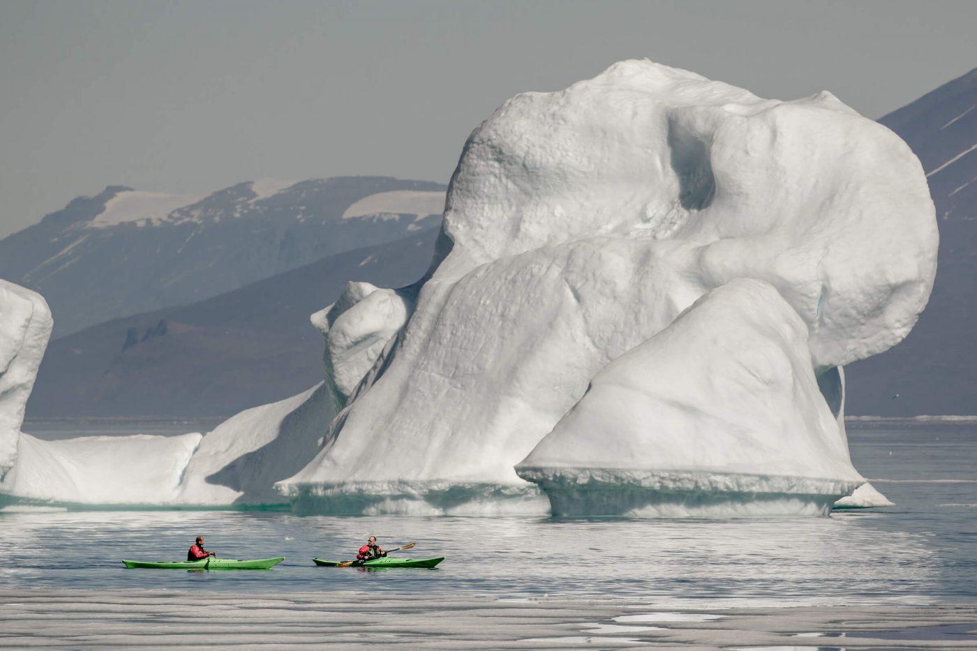 Kayakers near an iceberg in Illorsuit in North Greenland. By Mads Pihl