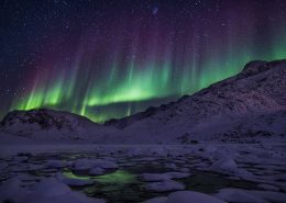 Northern lights over mountains. By Mads Pihl