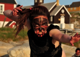 Woman mask dancing on a sunny day in Aasiaat. Photo by Honest Greenland - Visit Greenland