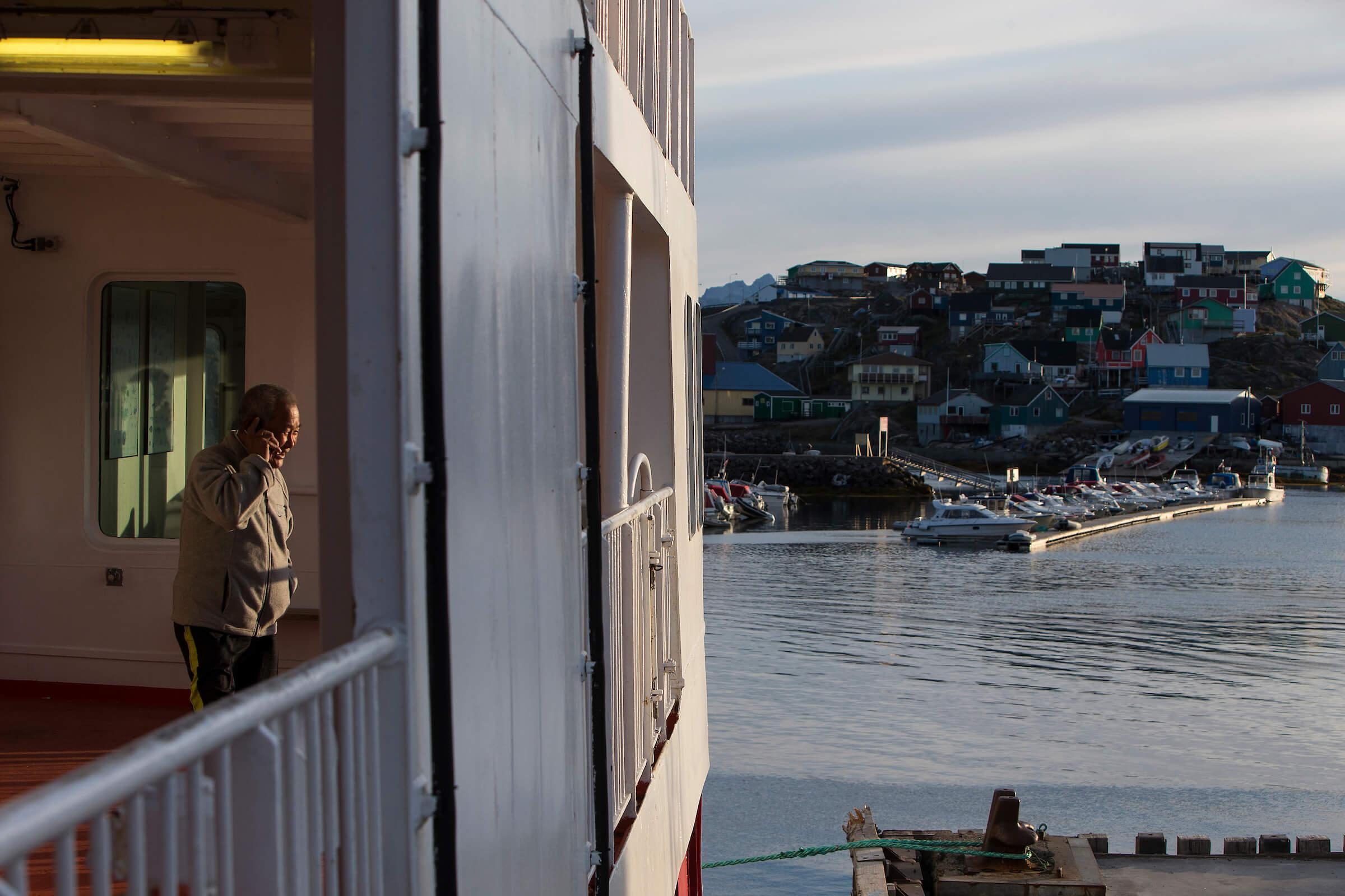 An elderly man talking on his cellphone while Sarfaq Ittuk was docked in Maniitsoq in Greenland. By Arctic Umiaq Line A/S