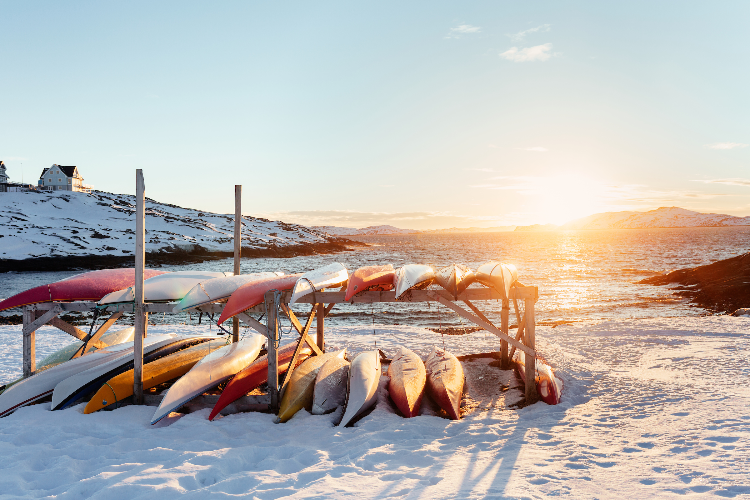 Backlit kayaks in a sunset scene in Nuuk in Greenland. Photo by Rebecca Gustafsson - Visit Greenland.