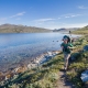 Male hiker walking on a path next to a lake on the Arctic Circle Trail. Photo by Lina Stock.