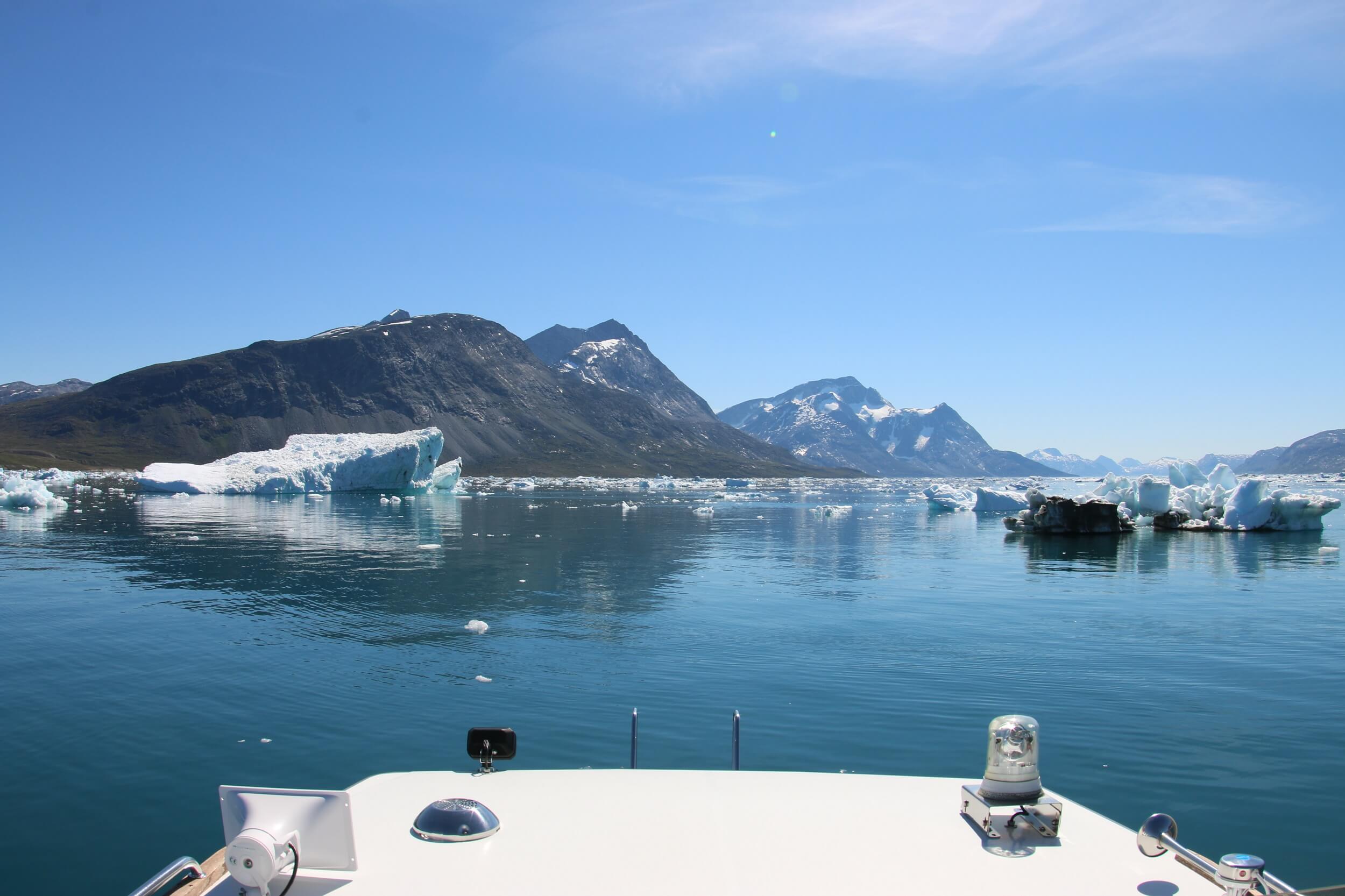 Boat sailing among icebergs in Nuup Kangerlua in summer. Photo by Nuuk Bay Adventues