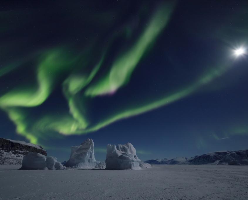 Sea Ice, Iceberg, Aurora Borealis and moon. Photo by Erez Marom - Visit Greenland