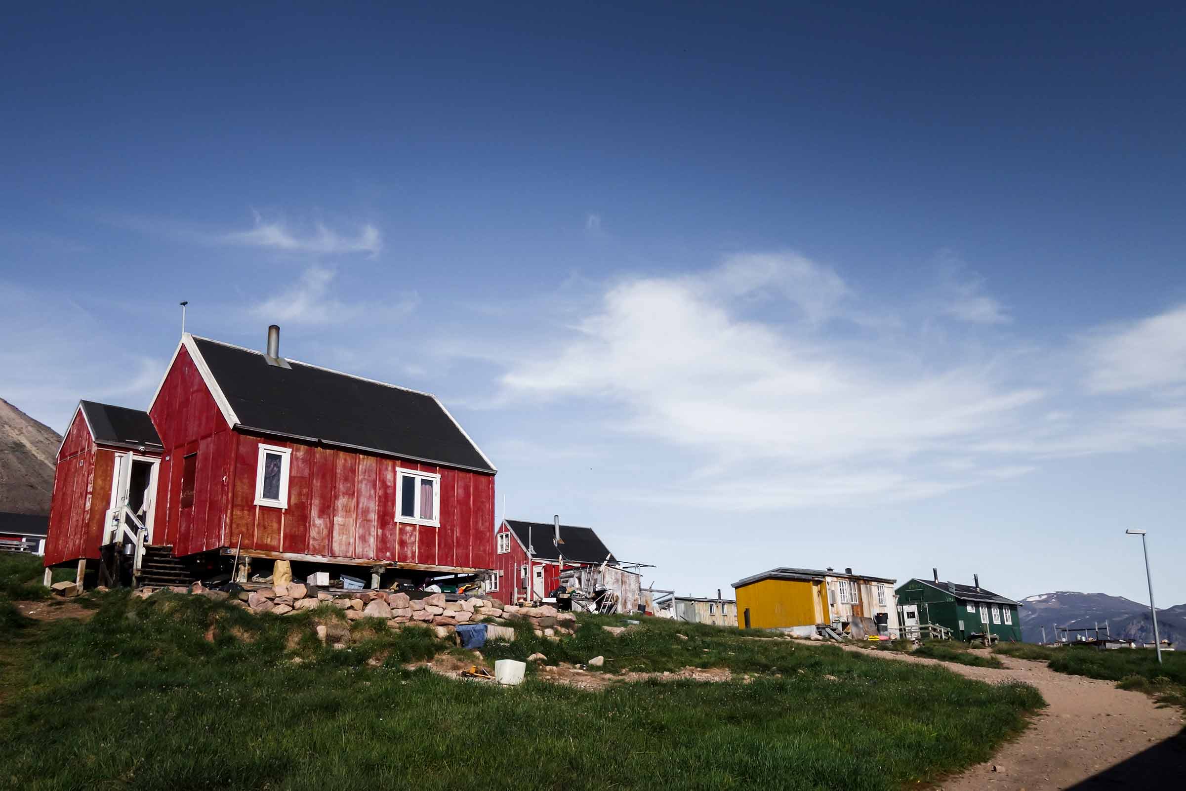 Red, yellow and green houses in Siorapaluk under the blue sky. Photo by Kim Insuk - Visit Greenland