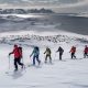 A group of skiers climbing a mountain near Kulusuk on a ski touring trip in East Greenland