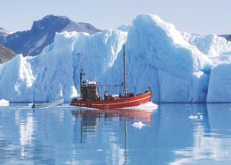 Saling vessel between icebergs in Greenland. Photo by Blue Ice Explorer, Visit Greenland.
