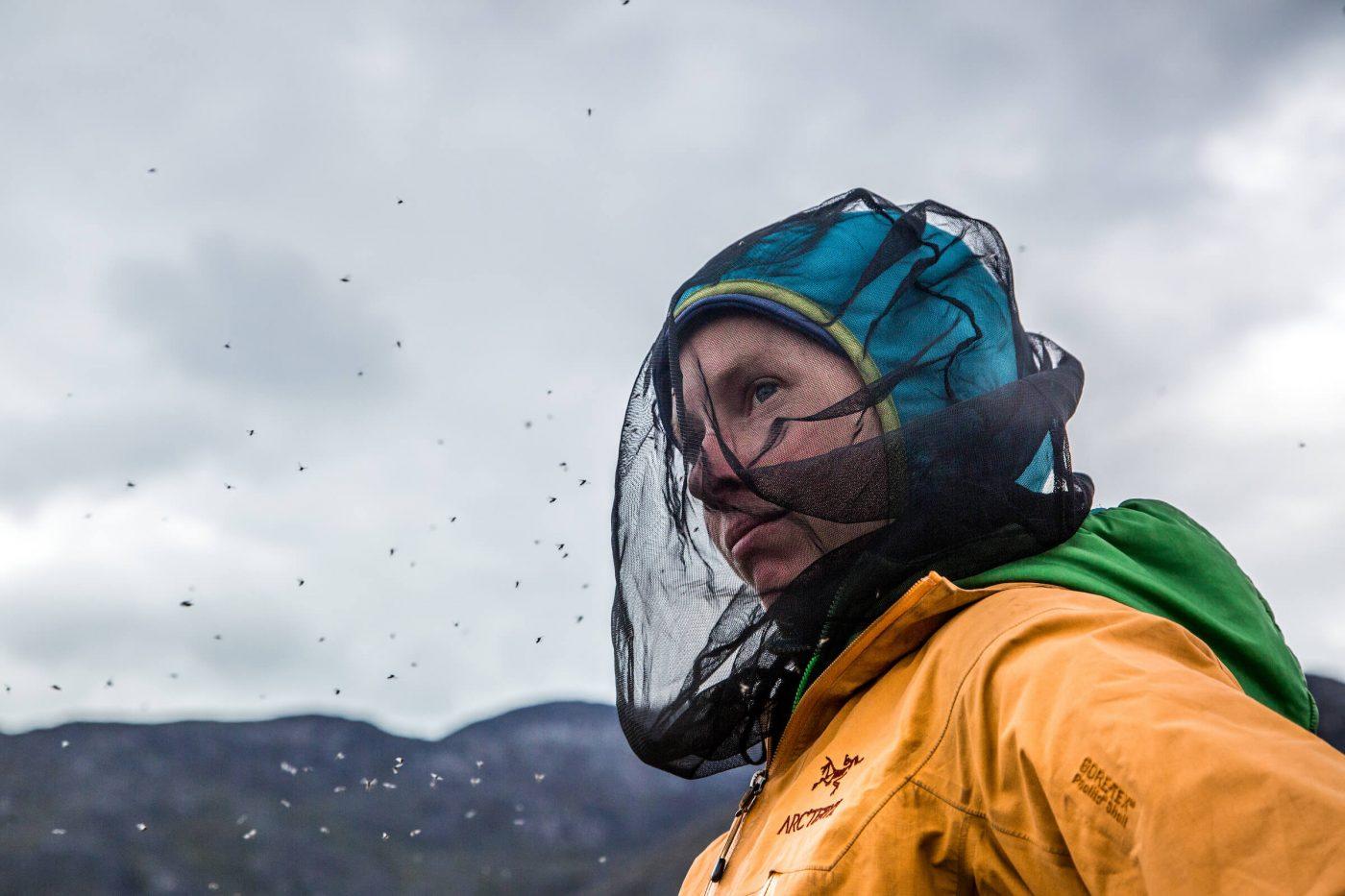 Hiker wards off pesky mosquitos by wearing a mosquito head net while adventuring in Nuuk Fjord. Photo by Raven Eye Photography