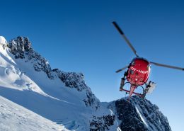 Air Greenland helicopter flying above mountains. By Humbert Entress
