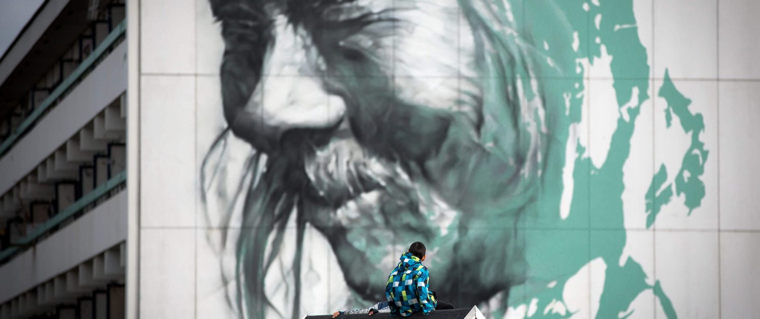 Modern Art - A boy from Nuuk looking at Guido Van Helten's wall art in Greenland