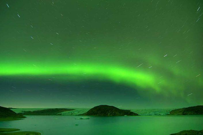 Long exposure photograph of the stars and northern lights above South Greenland. Visit Greenland