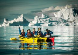 Kayakers mong icebergs near Ilulissat and Oqaatsut in North Greenland