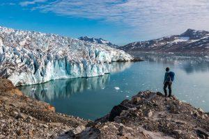 Hiker looking at Knud Rasmussen glacier in East Greenland. Photo by Pirhuk - Greenland Expedition Specialists