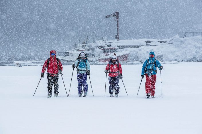 Ski touring skiers in heavy snowfall in Kuummiut in East Greenland. Photo by Mads Pihl