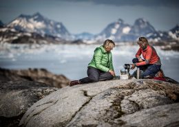 Two hikers at a camp in East Greenland preparing dinner. By Mads Pihl